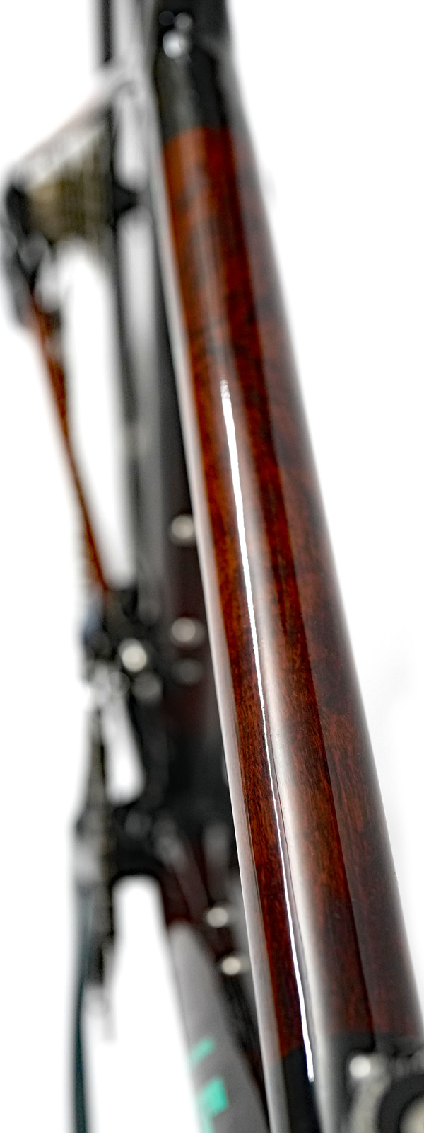 Light reflection on the clear gloss finish of a HTech Puissant HRP top tube, highlighting the wood grain of the Jarrah HRP tube