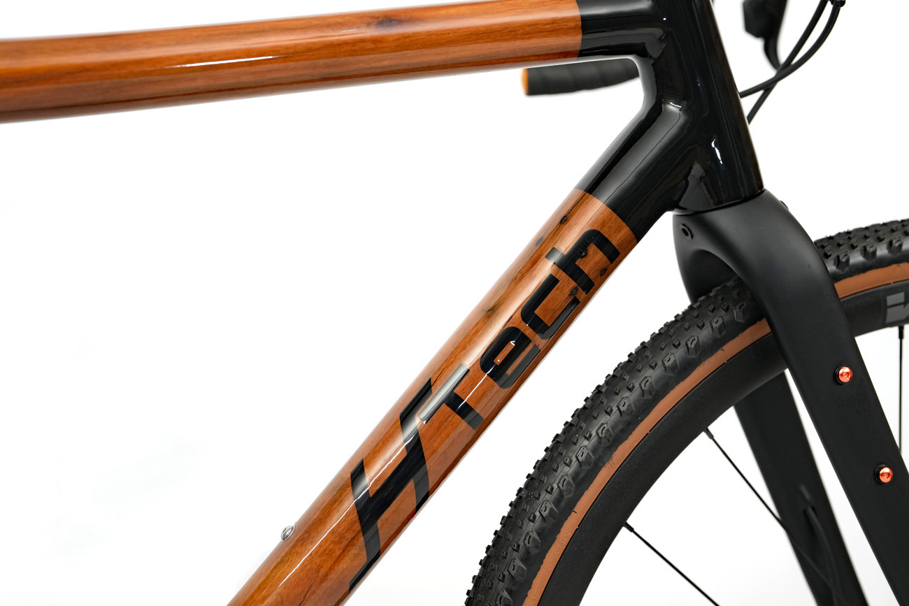 Black HTech logo on high gloss HRP recycled Karri down tube of Variantia gravel bike, highlighting unique wood grain and pattern